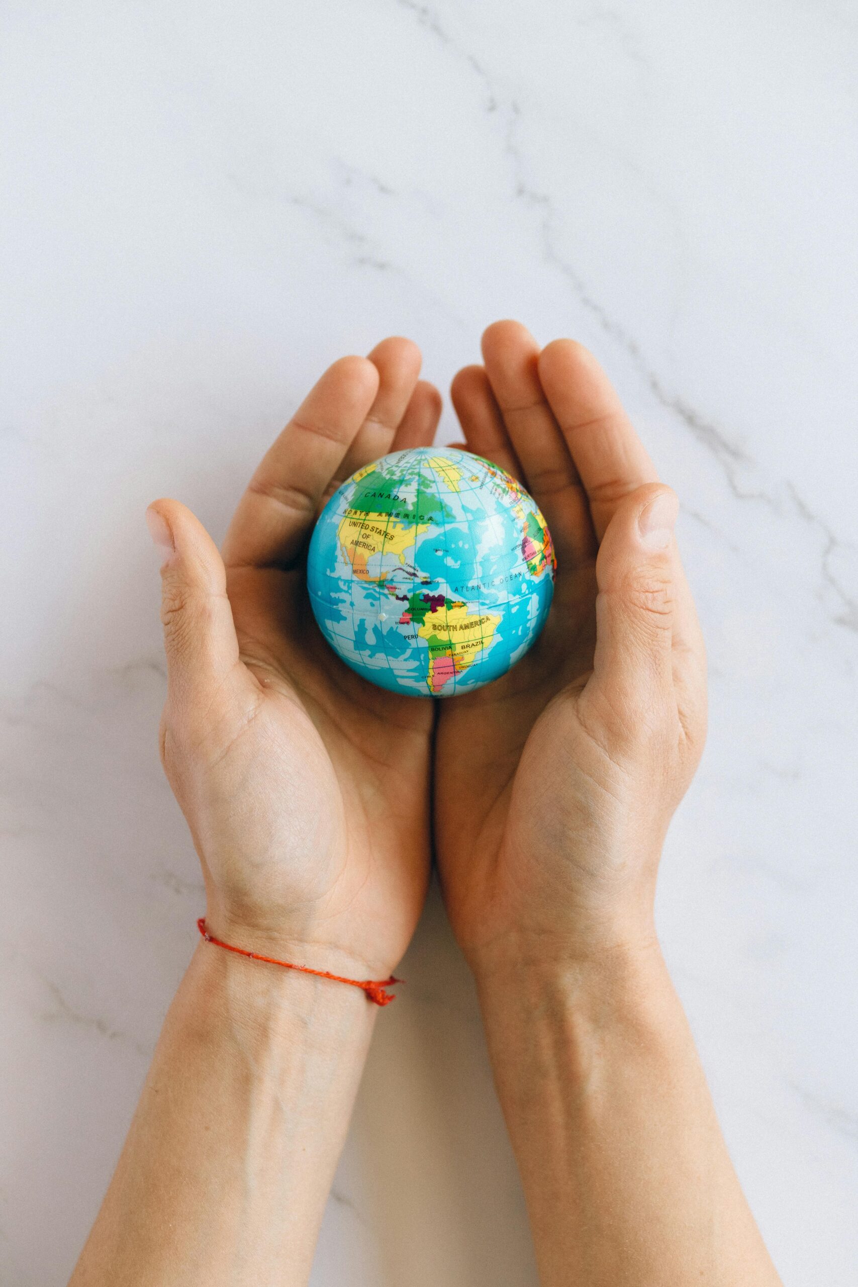 hands holding a small world globe
